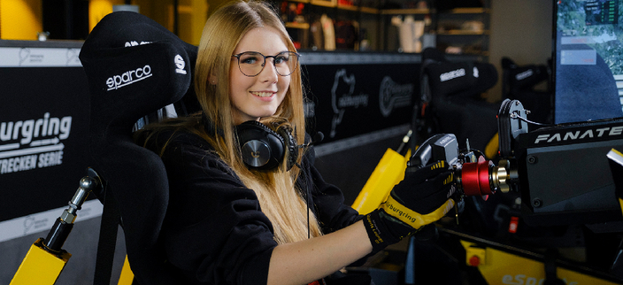 Mädchen sitzt in einem Fahrsimulator Mädchen sitzt in einem Fahrsimulator