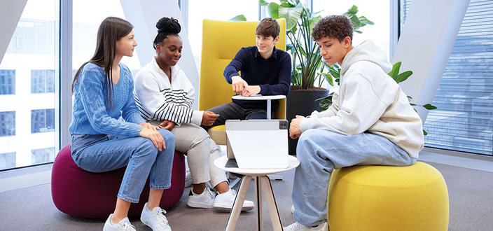 4 Personen sitzen auf großen Sitzkissen
