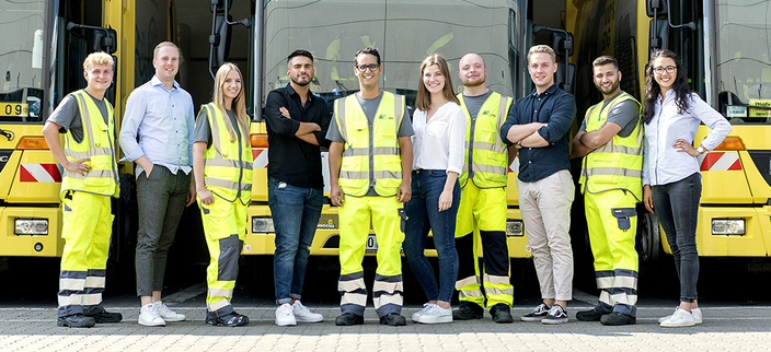 Gruppenfoto der Auszubildenden in Arbeitskleidung, im Hintergrund Einsatzfahrzeuge Gruppenfoto der Auszubildenden in Arbeitskleidung, im Hintergrund Einsatzfahrzeuge