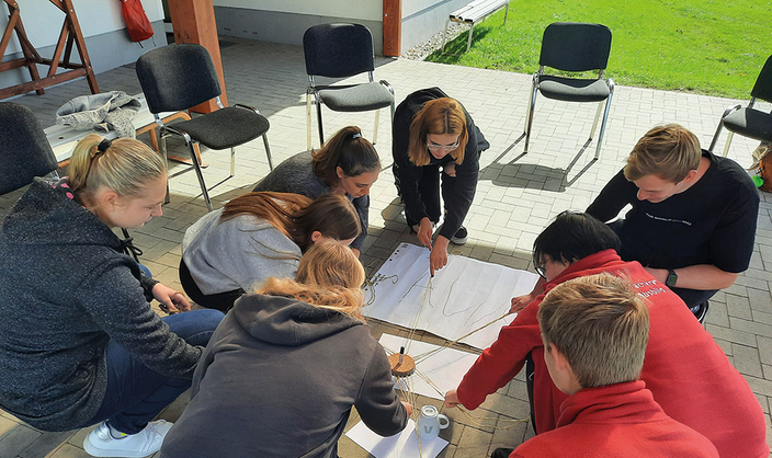 Junge Menschen sitzen im Kreis und arbeiten Junge Menschen sitzen im Kreis und arbeiten