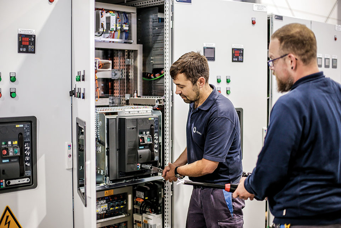 zwei Elektroniker arbeiten an einem Schaltkasten zwei Elektroniker arbeiten an einem Schaltkasten