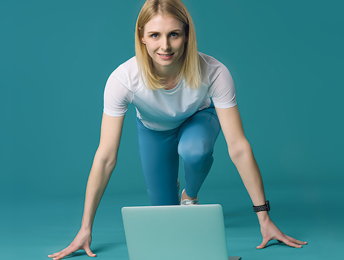 Person in Startposition vor einem Laptop
