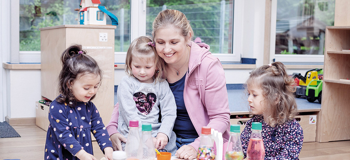 3 Kinder und eine Frau, die gemeinsam Frühstück machen