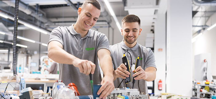 Zwei Personen arbeiten mit elektrischen Geräten Zwei Personen arbeiten mit elektrischen Geräten