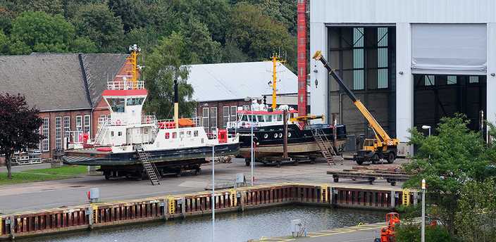 Es wird ein Schiffshebewerk mit zwei Schiffen an Deck gezeigt. Es wird ein Schiffshebewerk mit zwei Schiffen an Deck gezeigt.
