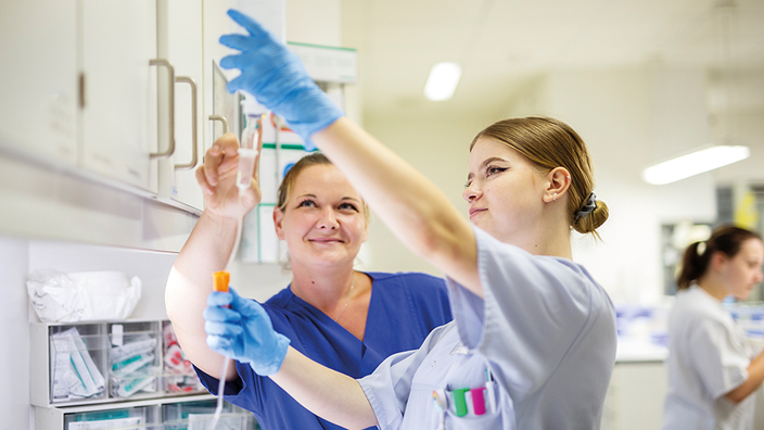 Zwei Junge Frauen im Krankenhaus bei der Arbeit.