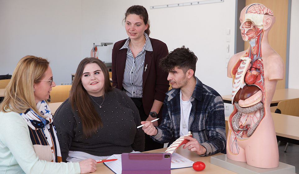 Kleine Lerngruppe Schüler und Schülerin mit zwei Lehrerinnen 