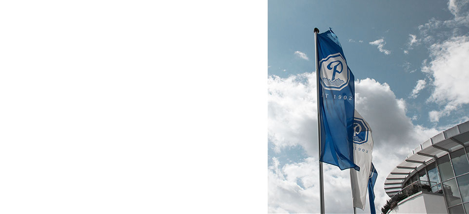 Fahnen mit Logo vor blauem Himmel mit Wolken