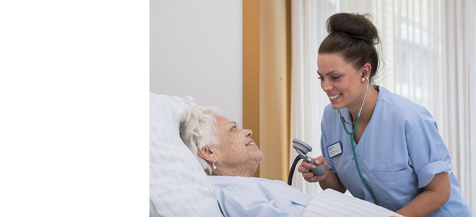 Pflegefachfrau am Bett einer Patientin