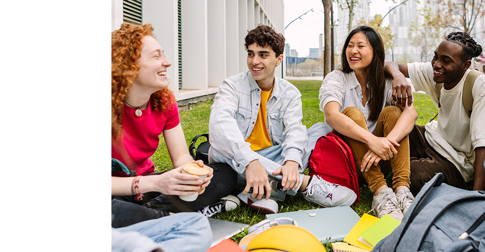 Vier Studenten sitzen lachend zusammen Vier Studenten sitzen lachend zusammen