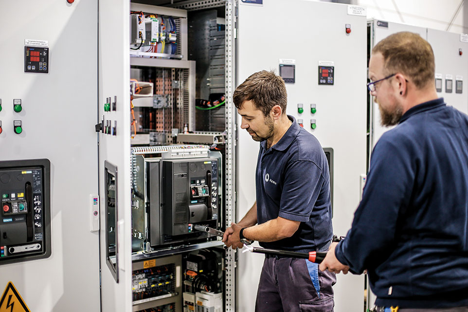 zwei Elektroniker arbeiten an einem Schaltkasten