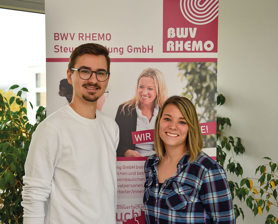 Zwei Personen stehen vor einem BWV RHEMO Banner
