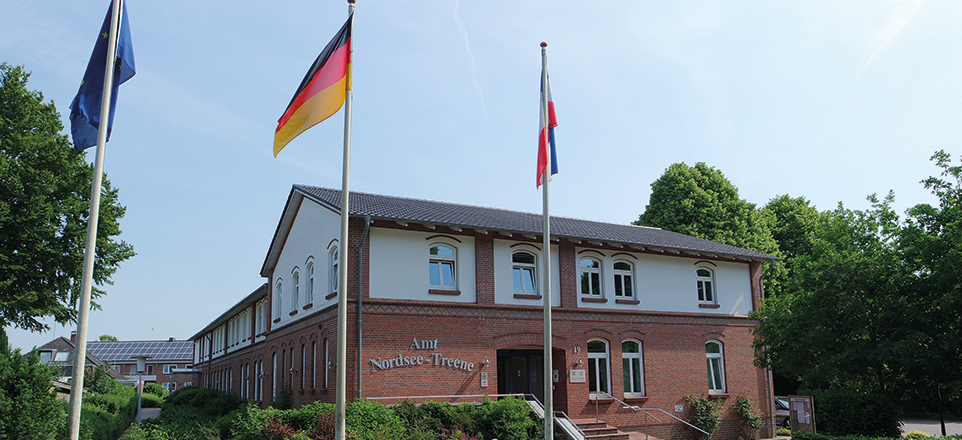Das Gebäude des Amts Nordsee-Treene mit gehissten Flaggen davor