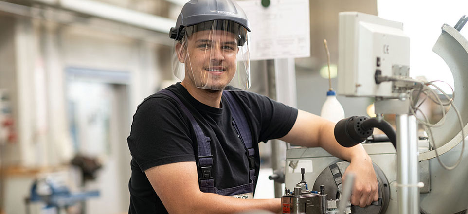Auszubildender von bremenports mit Schutzhelm in der Produktion