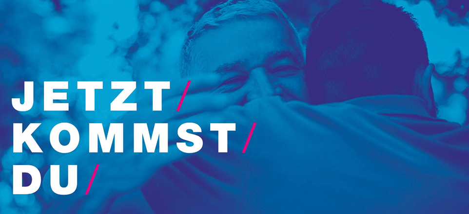 Blau eingefärbtes Bild von zwei Personen, die sich umarmen, Bildaufschrift: Jetzt kommst du