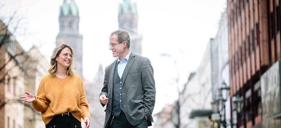 Zwei Personen im Vordergrund, im Hintergrund eine Kirche. Zwei Personen im Vordergrund, im Hintergrund eine Kirche.