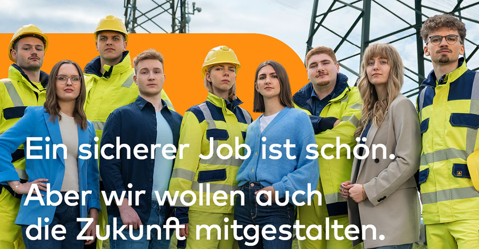 Personengruppe, teilweise mit Arbeitskleidung und Helm.