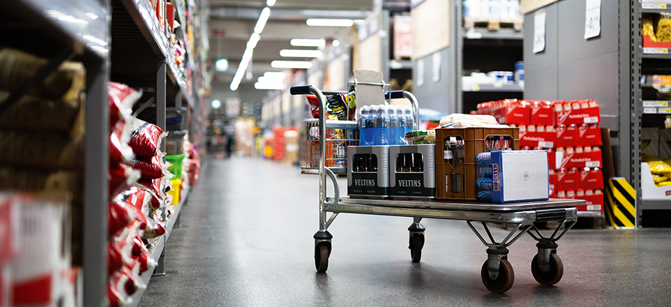 Vollgepackter Einkaufswagen in Warenlager