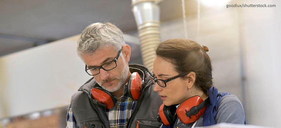 Handwerksmeister im Gespräch mit einer Mintarbeiterin
