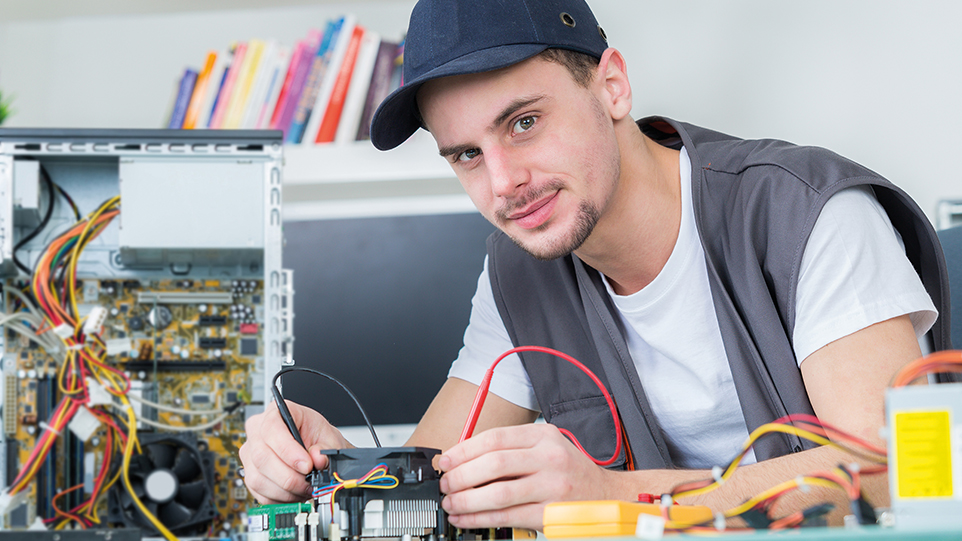 Junger Mann arbeitet an offenem Rechner Junger Mann arbeitet an offenem Rechner