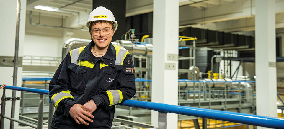 Junge Frau mit Arbeitskleidung und Helm Junge Frau mit Arbeitskleidung und Helm