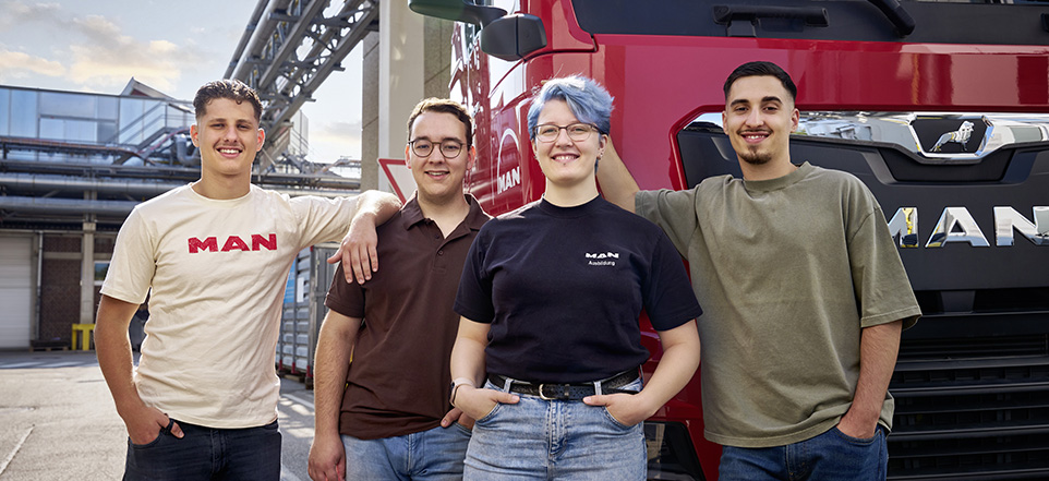 4 junge MAN Mitarbeitende vor einem MAN Truck 4 junge MAN Mitarbeitende vor einem MAN Truck