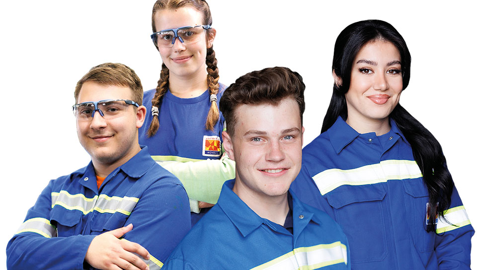 Vier Azubis in blauer Arbeitskleidung Vier Azubis in blauer Arbeitskleidung