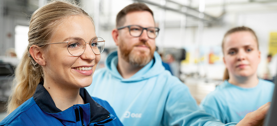 Junger Mann und Frau an einer Maschine am arbeiten