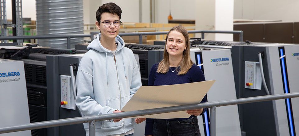 Zwei junge lächelnde Menschen in der Produktionsstätte