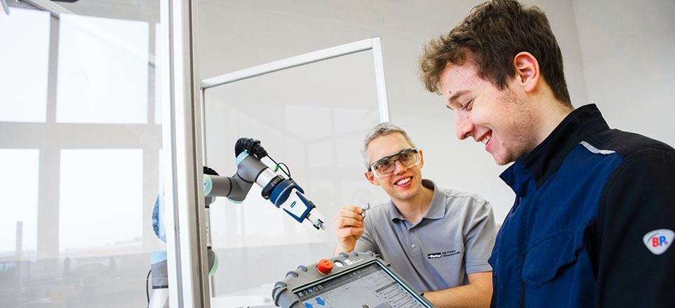 2 Personen bei der Arbeit an einer Maschine.
