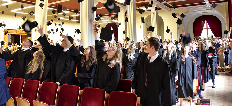 Studierende werfen ihre Hüte hoch
