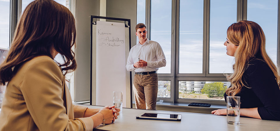 Kleine Gruppe im Meeting vor Flipchart Kleine Gruppe im Meeting vor Flipchart