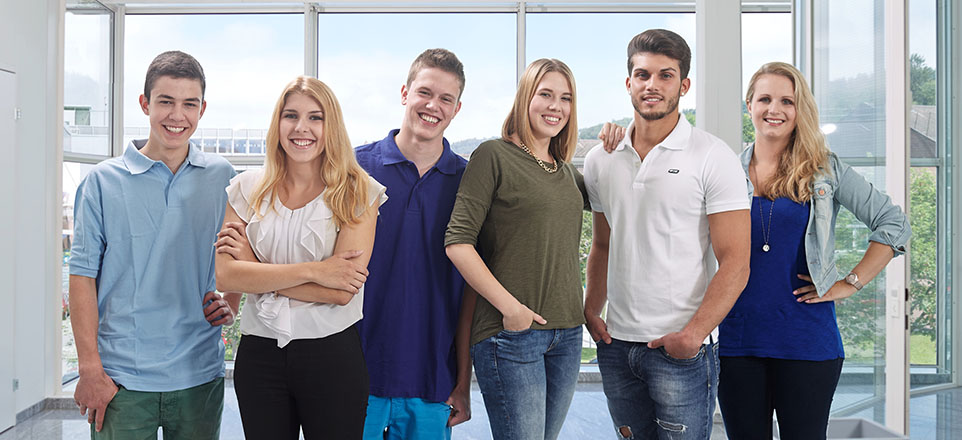 3 junge Männer und 3 junge Frauen stehen nebeneinander und lächeln in die Kamera 3 junge Männer und 3 junge Frauen stehen nebeneinander und lächeln in die Kamera